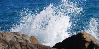 Bagnante su scogli trascinato in mare da onda, disperso